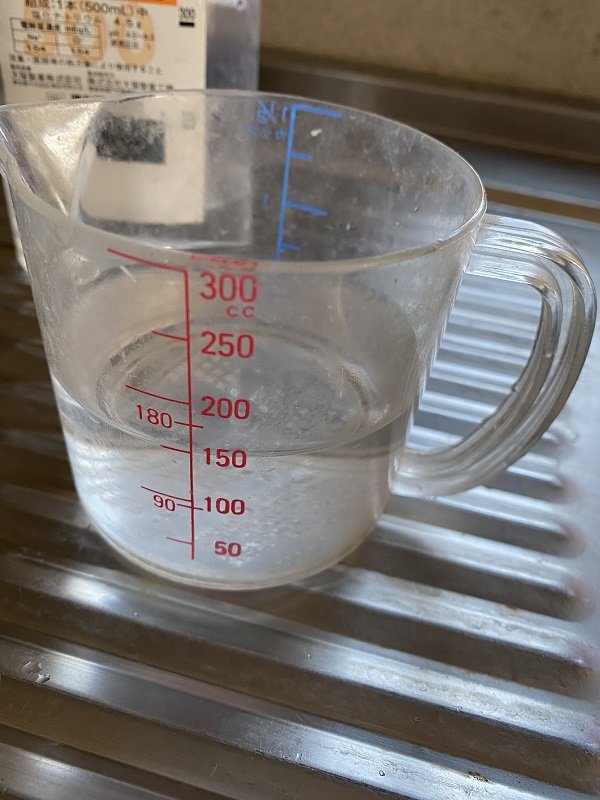 150mlの生理食塩水が入った計量カップ